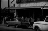 Protestors carrying signs while marching past the V. J. Elmore store in downtown Prattville, Alabama, during a civil rights demonstration.