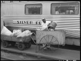 Worker emptying trash from Zephyr coach, 14th Street passenger yards, Chicago, May 1948