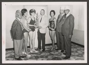 Women Holding Trophies with Men Wearing Fezzes