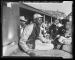 Satchel Paige with bat boys in dugout watching game in Los Angeles, Calif., circa 1943