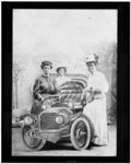 [Three African-American women posed with studio prop automobile in photographer's studio]