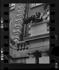 Student seen outside on balcony of Boston University administration building holding a jacket