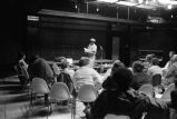 Etheridge Knight: Oxford, Miss. Knight performing at microphone in front of small audience (EKP 2-79-12/11 #295)