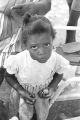 Little girl standing in the dirt yard in front of a house in Newtown, a neighborhood in Montgomery, Alabama.