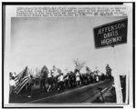 Civil rights marchers, one trailing an American flag, trudge along U.S. Highway 80, named in honor of the president of the Confederacy, as they make their way toward Montgomery and the state capitol