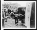 Horrible examples of Nazi brutality found by American 3rd Armd [sic] Div., FUSA when it captured the German slave labor camp at Nordhausen ... American medics place an almost-dead German slave in an ambulance