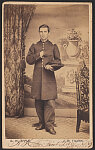 [Captain Anslem Hobbs of Co. B, 11th Indiana Infantry Regiment and 58th U.S. Colored Troops Infantry Regiment (USCT) in uniform in front of backdrop showing vase of flowers on pedestal in outdoor setting]