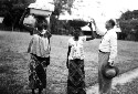 Sona Bata-Congo Belge Women with Cassava in pans on heads. Getting ready for dinner