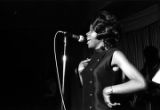 Woman performing on stage with Bobby Moore and the Rhythm Aces during a New Year's celebration at the Laicos Club in Montgomery, Alabama.