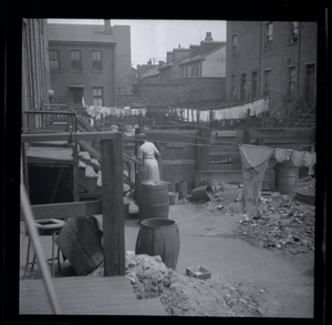 Woman and laundry in alley : photonegative.