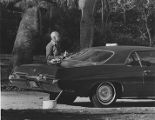 Older man washes car