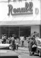 Protestors carrying signs while marching past Rexall Drugs in downtown Prattville, Alabama, during a civil rights demonstration.