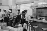 Police officers escorting African Americans out after a sit-in at either Lane Drugs or Tutwiler Drug in Birmingham, Alabama.