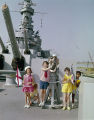 Children standing around an anti-aircraft gun on the deck of the USS Alabama in Mobile, Alabama.