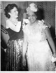 Loudella Lyons placing hat on unidentified woman