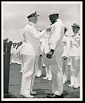 Admiral Chester W. Nimitz, USN, Commander-in-Chief, Pacific Fleet, pins the Navy Cross on Doris Miller, Steward's Mate 1/c, USN, at a ceremony on board a U.S. Navy warship in Pearl Harbor, T.H., May 27, 1942