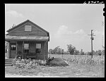 House in Negro section, Detroit, Michigan. Concrete wall in background is one half mile long, and serves to separate Negro section from white subdivision