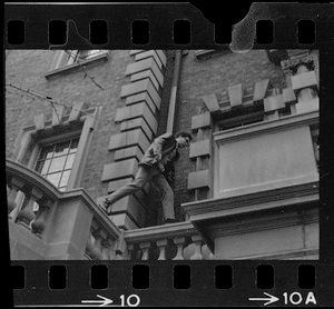 Student leaps across a balcony ruling over entrance to administration building at Boston University