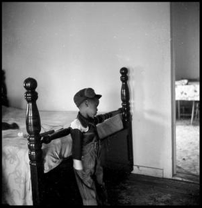 Young Boy Leaning on a Bed