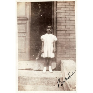 "Birdie" stands on steps of an unidentified building