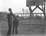 Ralph Metcalfe playing basketball with a young man, 1936