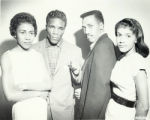 Four people posing for a group photograph