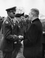 William Kelley, S.J., shakes hands with Jim Estes, a Marquette University ROTC student, 1962-1963