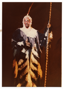 Performance picture of a man in a fur-type robe holding a staff]. [color photoprint