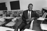 Howard Fuller sits a a desk in a classroom, circa 1996