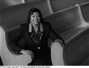 Dorothy N. Cole Davis seated among the pews of a church #4