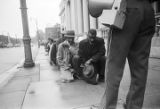 Fred Shuttlesworth and other civil rights demonstrators kneeling before a police officer during a protest march in downtown Birmingham, Alabama.