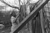 Mrs. Rosa Lee Turner hanging laundry on a clothesline in the dirt yard behind her house in Montgomery, Alabama.