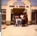 Series of two Polaroid photographs of Tracy Lewis with principal displaying donation from WAAK-UP