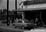 Protestors carrying signs while marching past the V. J. Elmore store in downtown Prattville, Alabama, during a civil rights demonstration.