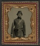 [Unidentified soldier in Confederate frock coat and forage cap with cap box, bayoneted musket, and holstered revolver]