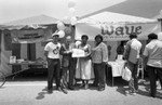 Crenshaw Festival participants from the Crenshaw Chamber of Commerce posing near their booth, Los Angeles, 1983