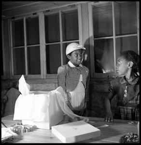 Sue Antoinette Emory Wearing a Checked Jacket and White Cap