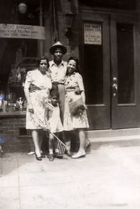 Lee and Chester Harris, godmother Bessie, and Henrietta Brown pose in front of building