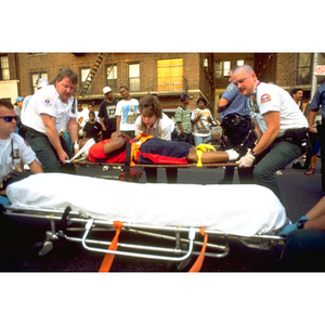 EMTs lift an injured man on a gurney