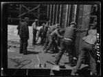 Building the SS Frederick Douglass. More than 6,000 Negro shipyard workers are employed at the Bethlehem-Fairfield shipyards, where the Liberty ship is being rushed to completion. The noted orator and abolitionist leader worked as a ship caulker in the vicinity of this yard before he escaped from slavery. Men setting bulkhead in place, running from tank deck to flat deck in aft of ship