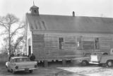 People entering a wooden church building in rural Prattville, Alabama, probably for a meeting of the Autauga County Voters Association.