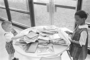 Little boy and girl looking at books on a table at the Montgomery Public Library.