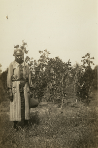 Gullah woman standing in front of bush