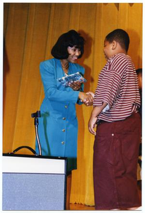 Woman Presenting Gift to Young Boy