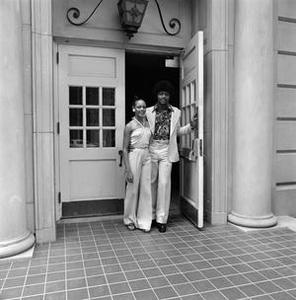 Two individuals exiting a building, 3