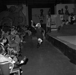 Woman moving and performing in front of a stage