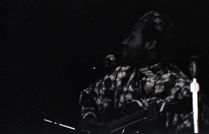 Taj Mahal in concert at Northfield, Mass.: Taj Mahal seated, playing steel guitar