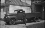 Fireman standing next to Oakland Fire Department truck parked in driveway of fire engine no. 22