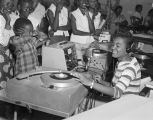 Female disc jockey, possibly DoDo Talley, from radio station WRMA in Montgomery, Alabama, playing records at Dozier's Radio Service on West Jeff Davis Avenue.