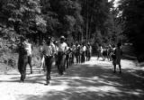 Edward Rudolph leading marchers down an unpaved road in Prattville, Alabama, during a demonstration sponsored by the Autauga County Improvement Association.